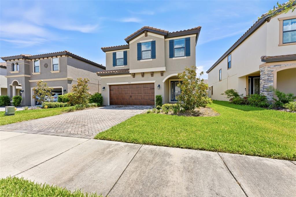 A two-story suburban house with a brown garage door and a paved driveway — 3940 MAURICE AVENUE, ODESSA, FL