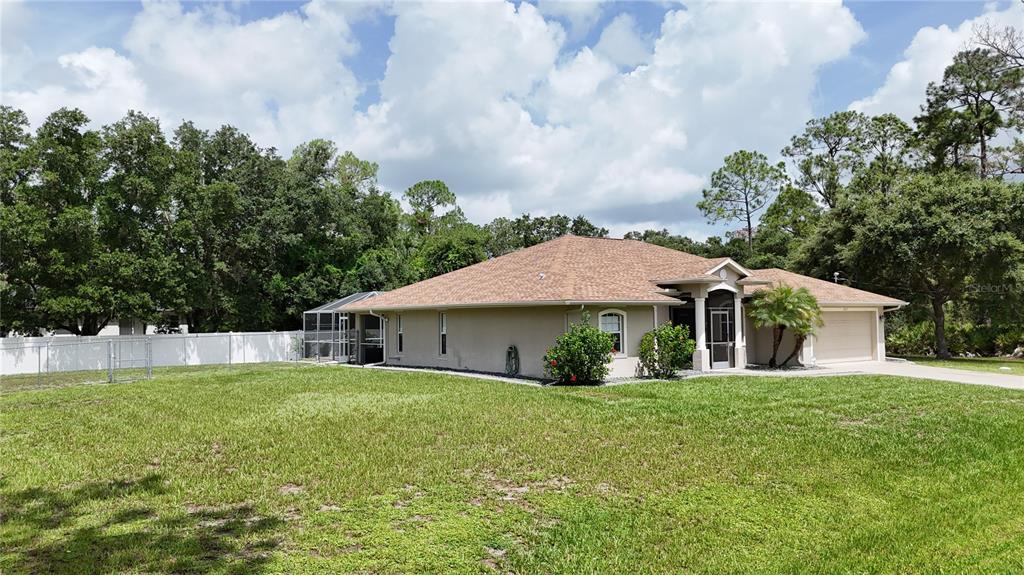 A single-story house with a tan exterior, brown roof, and a screened-in pool area — 2613 TRIANNA STREET, NORTH PORT, FL