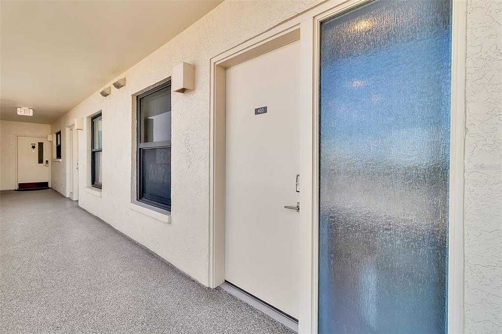 A view of an outdoor apartment building corridor with a door labeled 403 — 5740 MIDNIGHT PASS ROAD UNIT 403, SARASOTA, FL