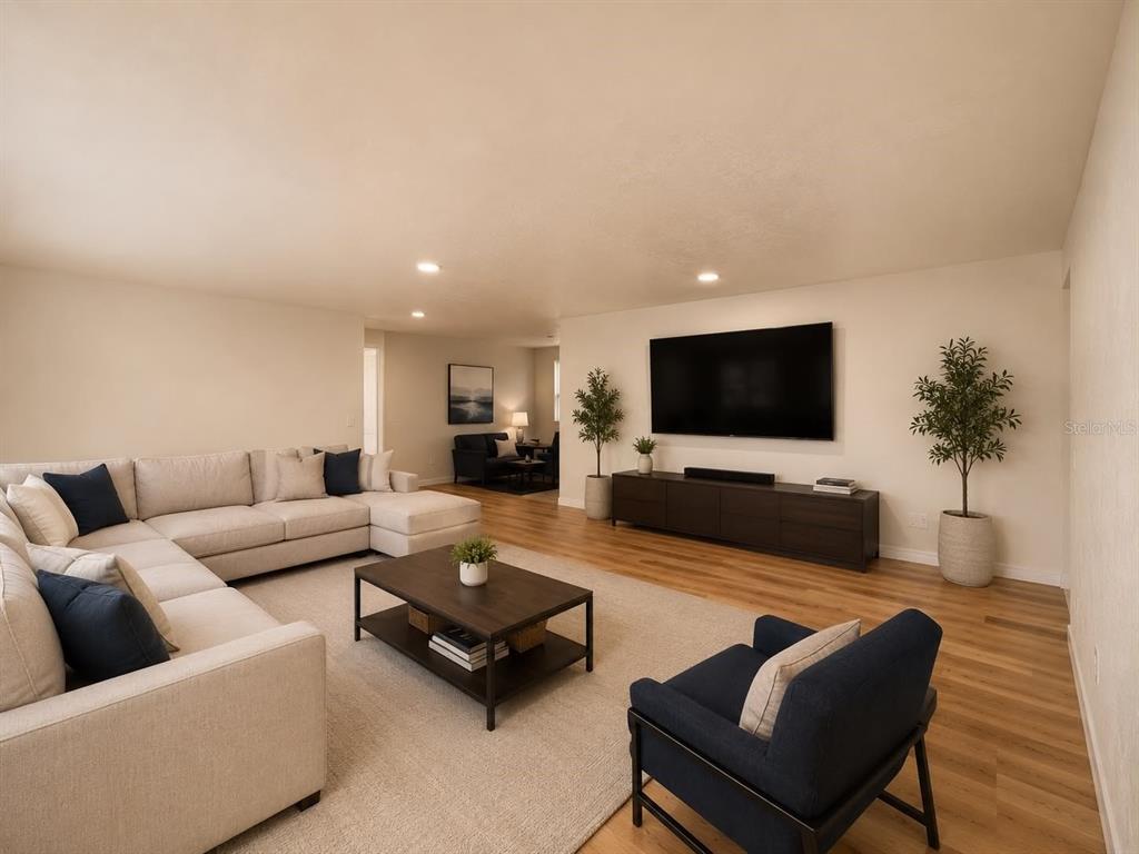 A living room features a large sectional sofa, a coffee table, and a wall-mounted television — 3115 LOCKWOOD MEADOWS BOULEVARD, SARASOTA, FL