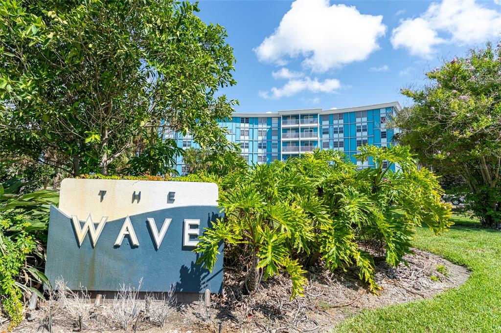 A sign for The Wave stands in front of a blue multi-story apartment building — 3315 58TH AVENUE S UNIT 512, ST PETERSBURG, FL