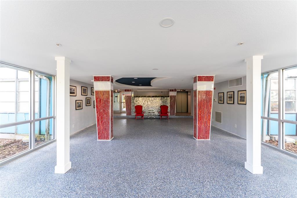 A lobby features two red chairs, tiled columns, and large windows on both sides — 3315 58TH AVENUE S UNIT 512, ST PETERSBURG, FL