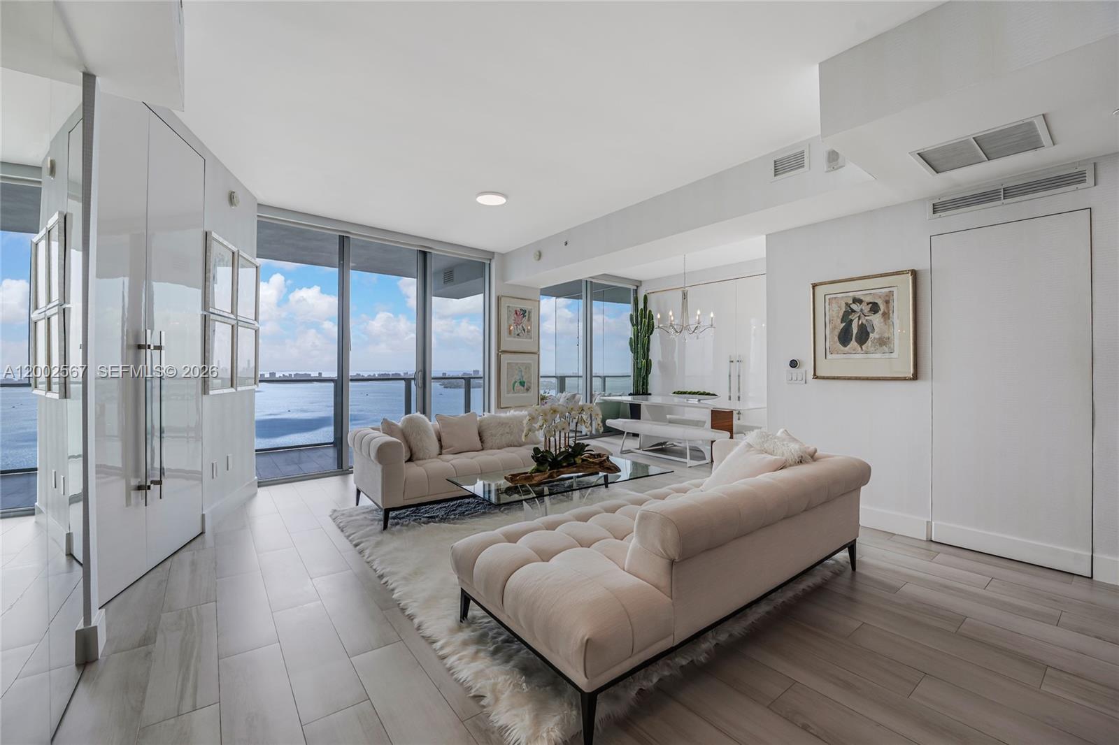 A modern living room features two tufted sofas, a glass coffee table, and floor-to-ceiling windows — 2900 NE 7th Ave # 4003, Miami FL 33137, MIAMI, FL