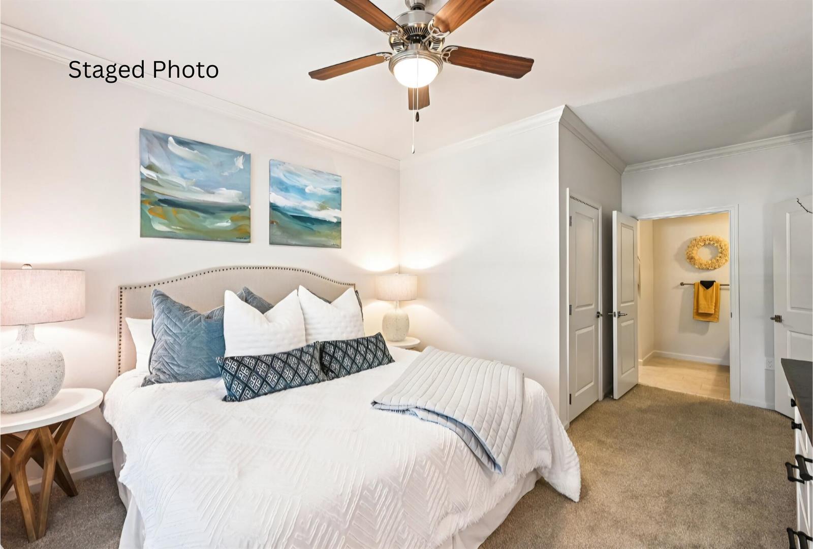 A staged bedroom features a queen bed, two nightstands with lamps, and an attached bathroom — 1900 NW Federal Highway, Stuart FL 34994, STUART, FL