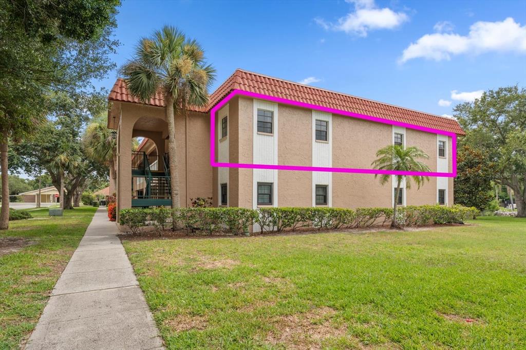 A two-story apartment building exterior with a pink outline highlighting the upper-level windows — 1750 BELLEAIR FOREST DRIVE UNIT B8, BELLEAIR, FL