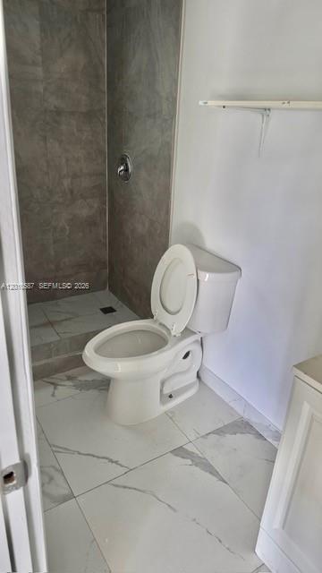 A bathroom features a white toilet, a walk-in shower with gray tiles, and white flooring — 1718 SW 57th Ave # 1, West Park FL 33023, WEST PARK, FL