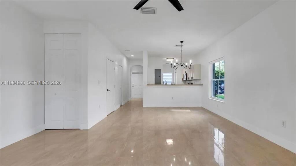 An open-concept living and dining area features white walls, tile flooring, and a kitchen pass-through — 4921 SW 140th Ter # 1, Miramar FL 33027, MIRAMAR, FL
