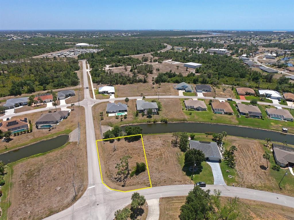 An aerial view shows a vacant residential lot outlined in yellow near a small pond — 133 FAIRWAY ROAD, ROTONDA WEST, FL