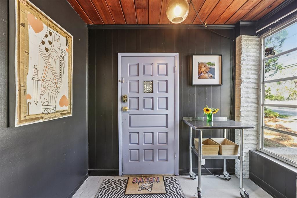 An entryway features a light purple door, dark paneled walls, and a stainless steel utility table — 4216 W EUCLID AVENUE, TAMPA, FL