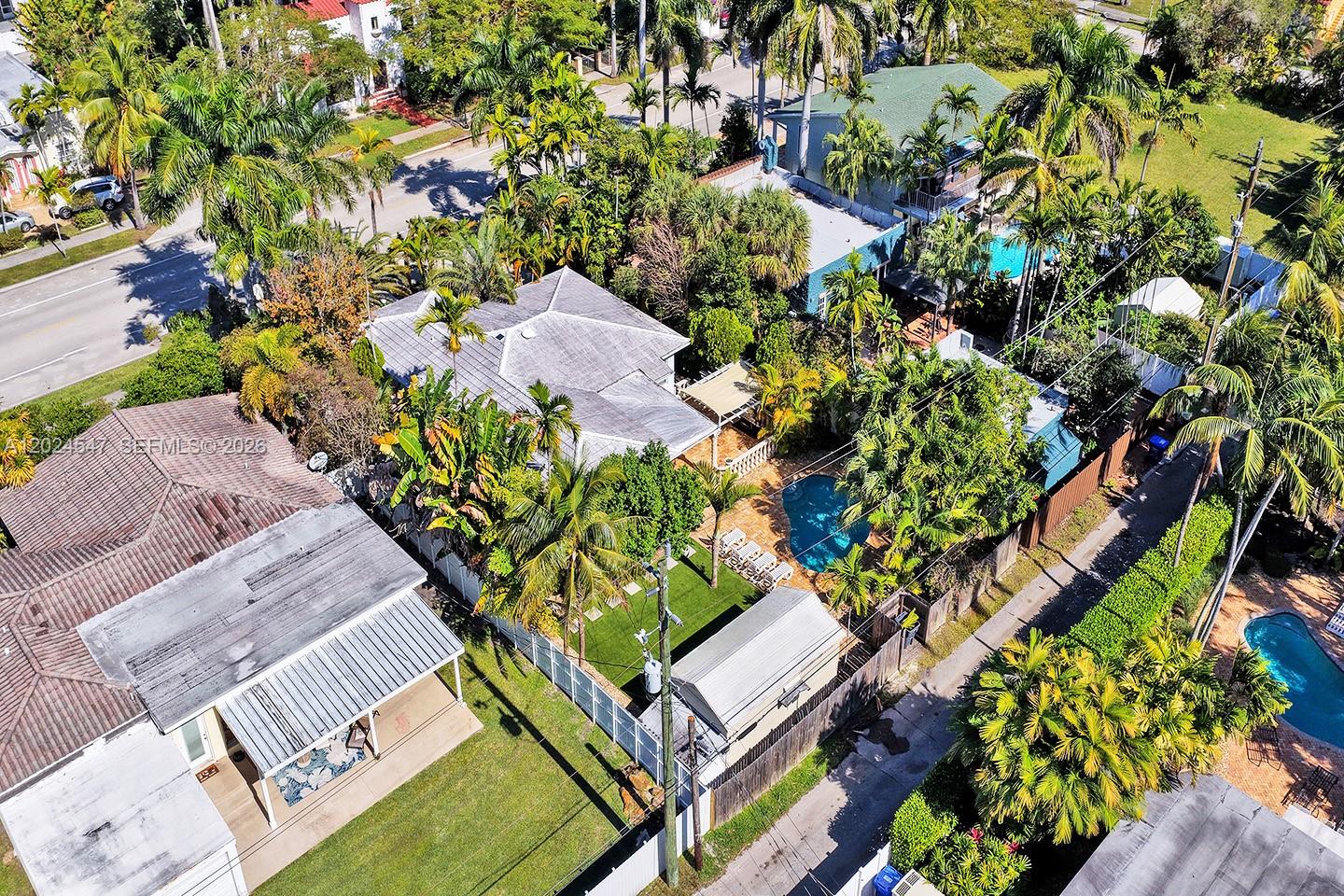 An aerial view shows a residential property with a pool, lush landscaping, and surrounding homes — 1016 Harrison St, Hollywood FL 33019, HOLLYWOOD, FL