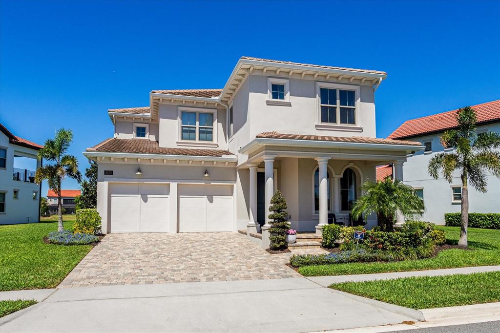 A two-story house with a two-car garage, light stucco exterior, and a tiled roof — 8222 TOPSAIL PLACE, WINTER GARDEN, FL