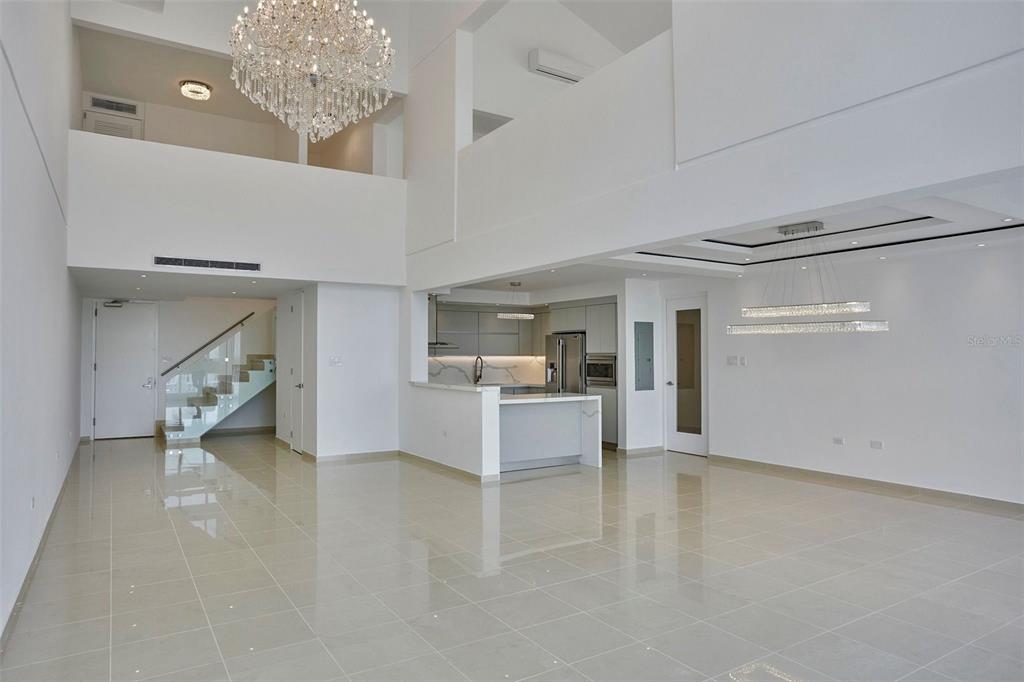 A spacious, modern open-concept living area features a high ceiling, chandelier, and tiled flooring — 405 CALLE INGENIERO JUAN B. RODRIGUEZ UNIT 1702, SAN JUAN, PR