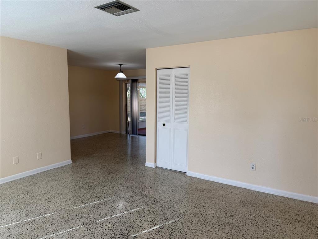 An interior view of a room with light-colored walls, white trim, and speckled flooring — 6452 TREEHAVEN DRIVE, SPRING HILL, FL