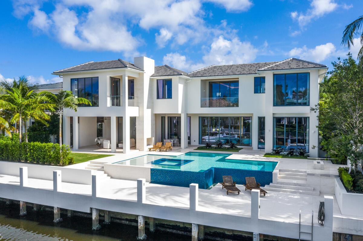 A modern two-story waterfront home features a swimming pool, patio, and private dock — 249 W Alexander Palm Road, Boca Raton FL 33432, BOCA RATON, FL