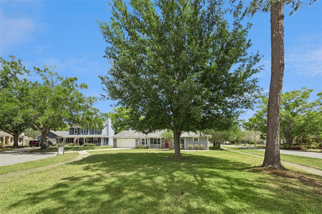 A covered front porch features a red door, gray siding, and potted plants — 7923 THURMOND COURT, ORLANDO, FL