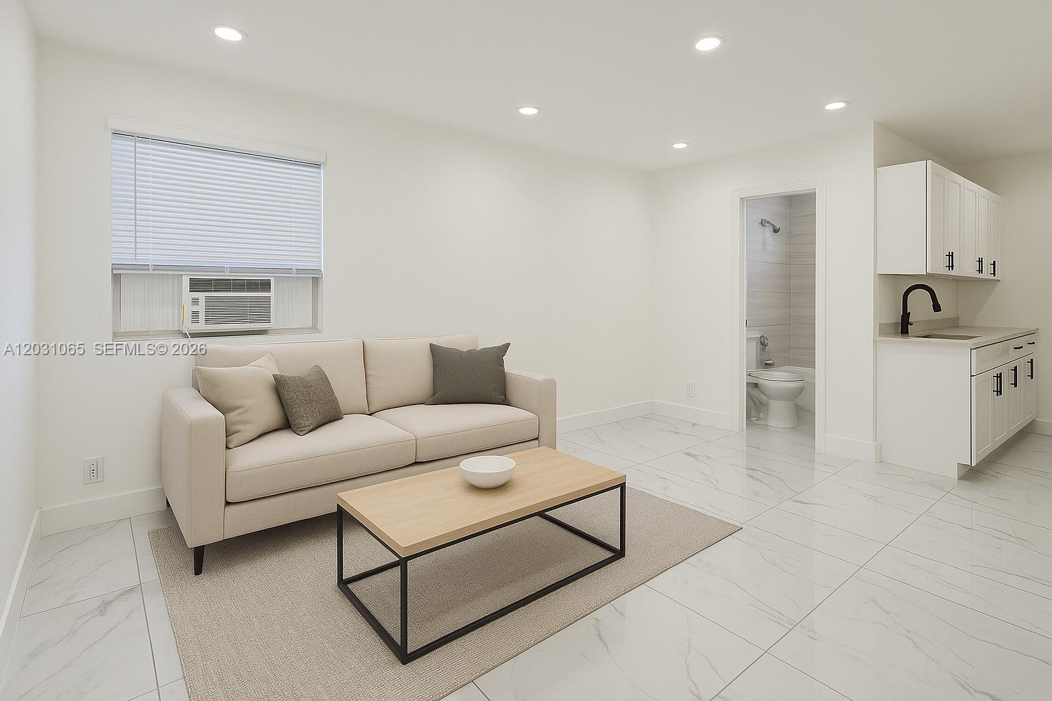 A studio apartment features a sofa, coffee table, kitchenette, and an attached bathroom — 5740 Mayo St # 4, Hollywood FL 33023, HOLLYWOOD, FL