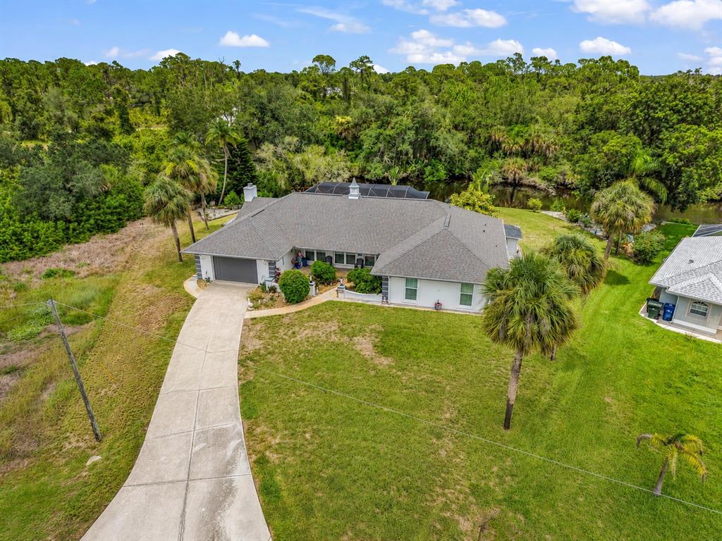 An aerial view shows a single-story house with a gray roof, garage, and surrounding lawn — 108 ANTILLA ROAD, NORTH PORT, FL