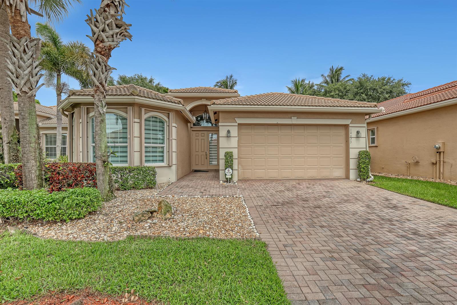 A single-story house with a beige stucco exterior, tile roof, and a paved driveway — 10673 Richfield Way, Boynton Beach FL 33437, BOYNTON BEACH, FL