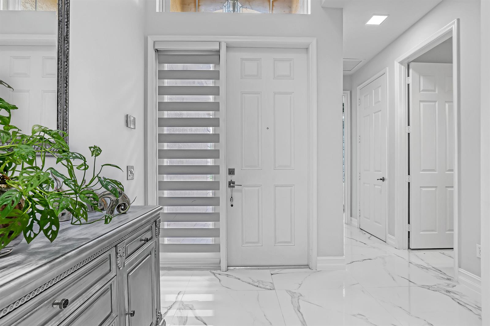 A bright entryway features white marble floors, a white front door, and a wooden console table — 10673 Richfield Way, Boynton Beach FL 33437, BOYNTON BEACH, FL