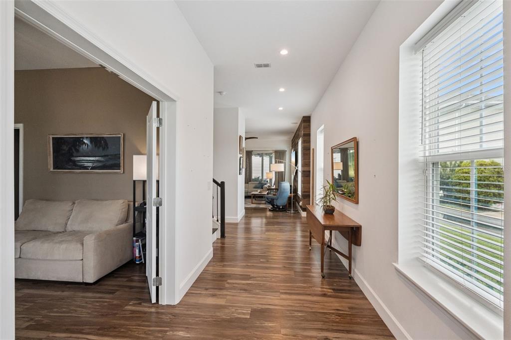 A hallway with wood-look flooring leads to a living area past a room with French doors — 13126 GRANGER AVENUE, ORLANDO, FL