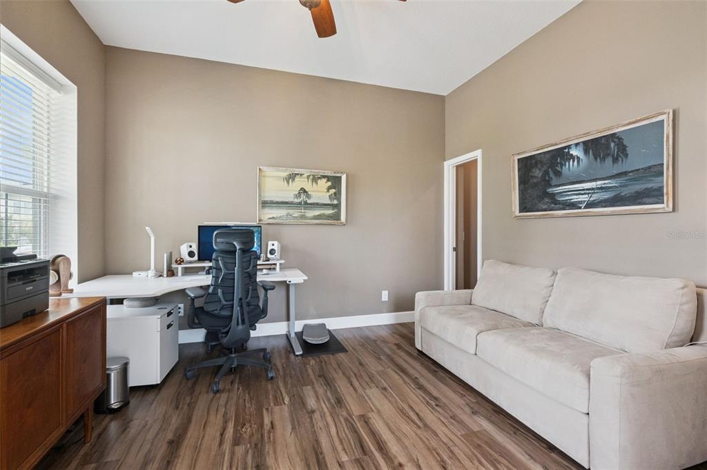 A home office features a white corner desk, a black ergonomic chair, and a beige sofa — 13126 GRANGER AVENUE, ORLANDO, FL