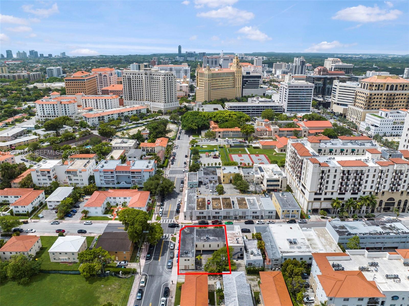 An aerial view shows a commercial building outlined in red within a dense urban area — 101 Madeira Ave, Coral Gables FL 33134, CORAL GABLES, FL