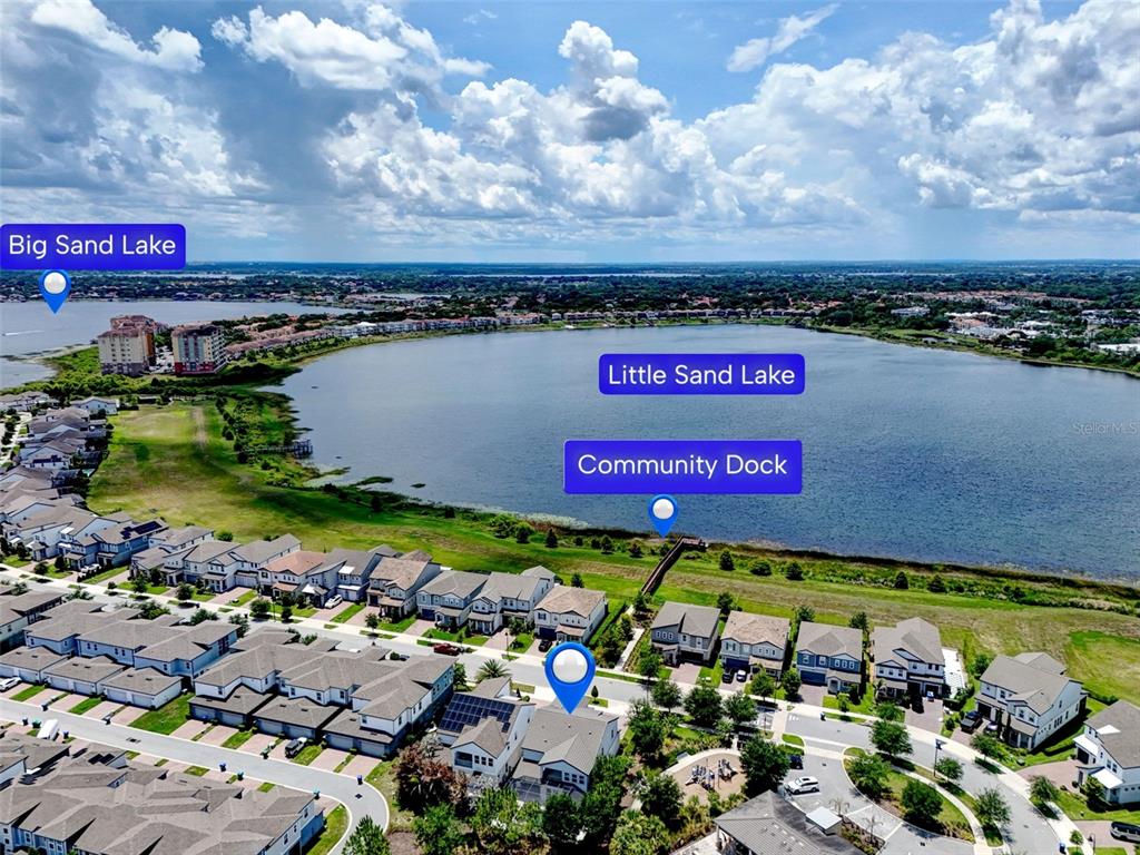 An aerial view shows a residential neighborhood situated next to a lake with a dock — 6048 BIMINI TWIST LOOP, ORLANDO, FL