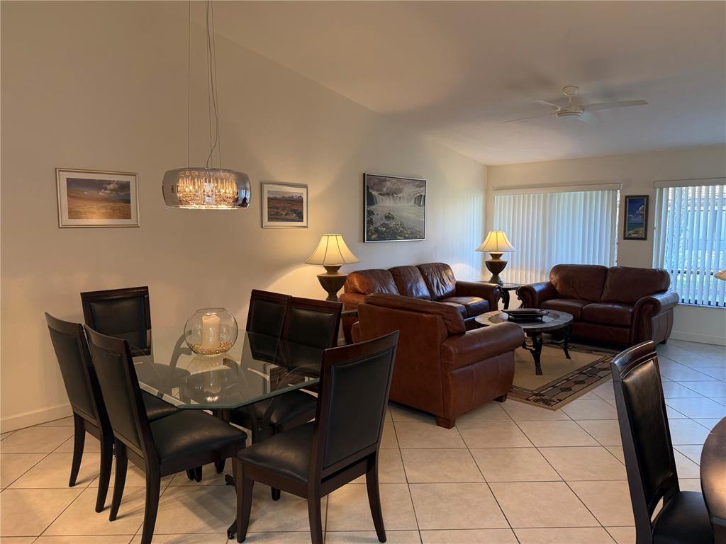 A dining area with a glass table and leather chairs sits beside a leather-furnished living room — 3637 YELLOW PINE COURT UNIT 146, SARASOTA, FL