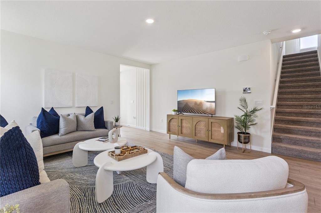 A living room features a sofa, two coffee tables, a media console, and a staircase — 5199 NICKERBEAN STREET, APOPKA, FL