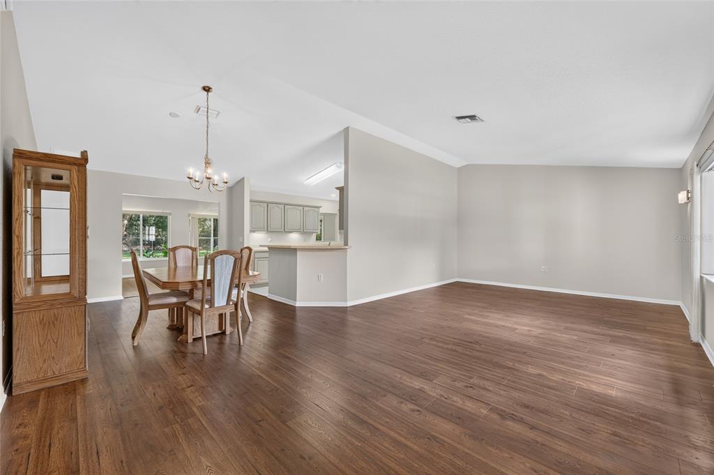 A dining area with a wooden table and chairs sits adjacent to an open kitchen — 11268 SW 139TH PLACE, DUNNELLON, FL