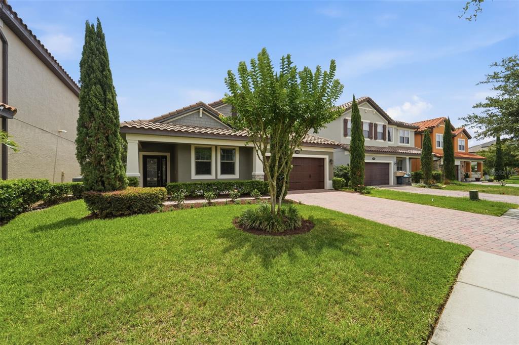 A single-story house with a brick driveway, a green lawn, and a central tree — 175 ANCONA AVENUE, DEBARY, FL
