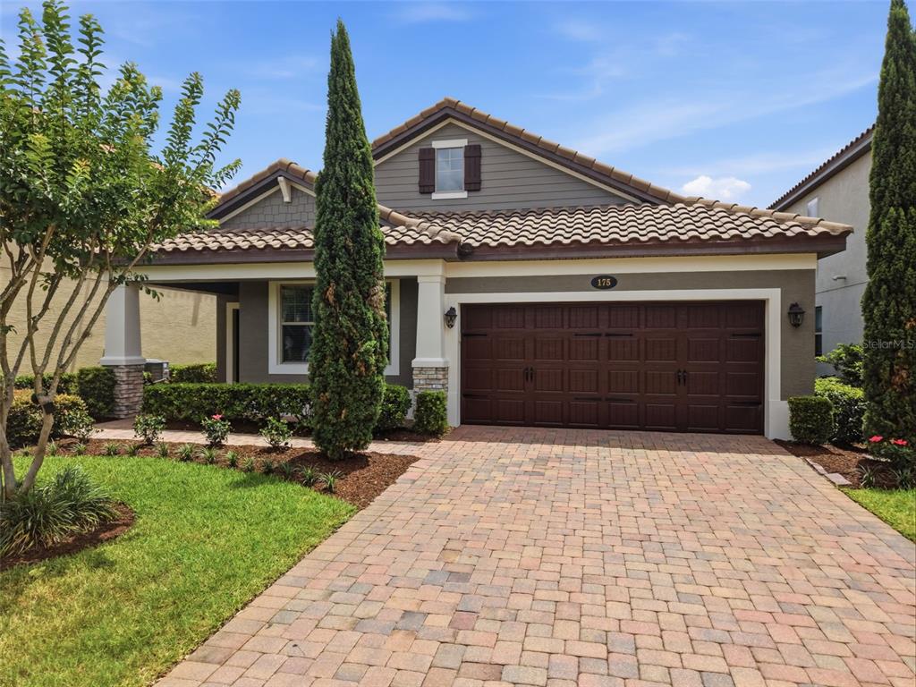 A single-story house with a brown garage door, tiled roof, and a brick paver driveway — 175 ANCONA AVENUE, DEBARY, FL