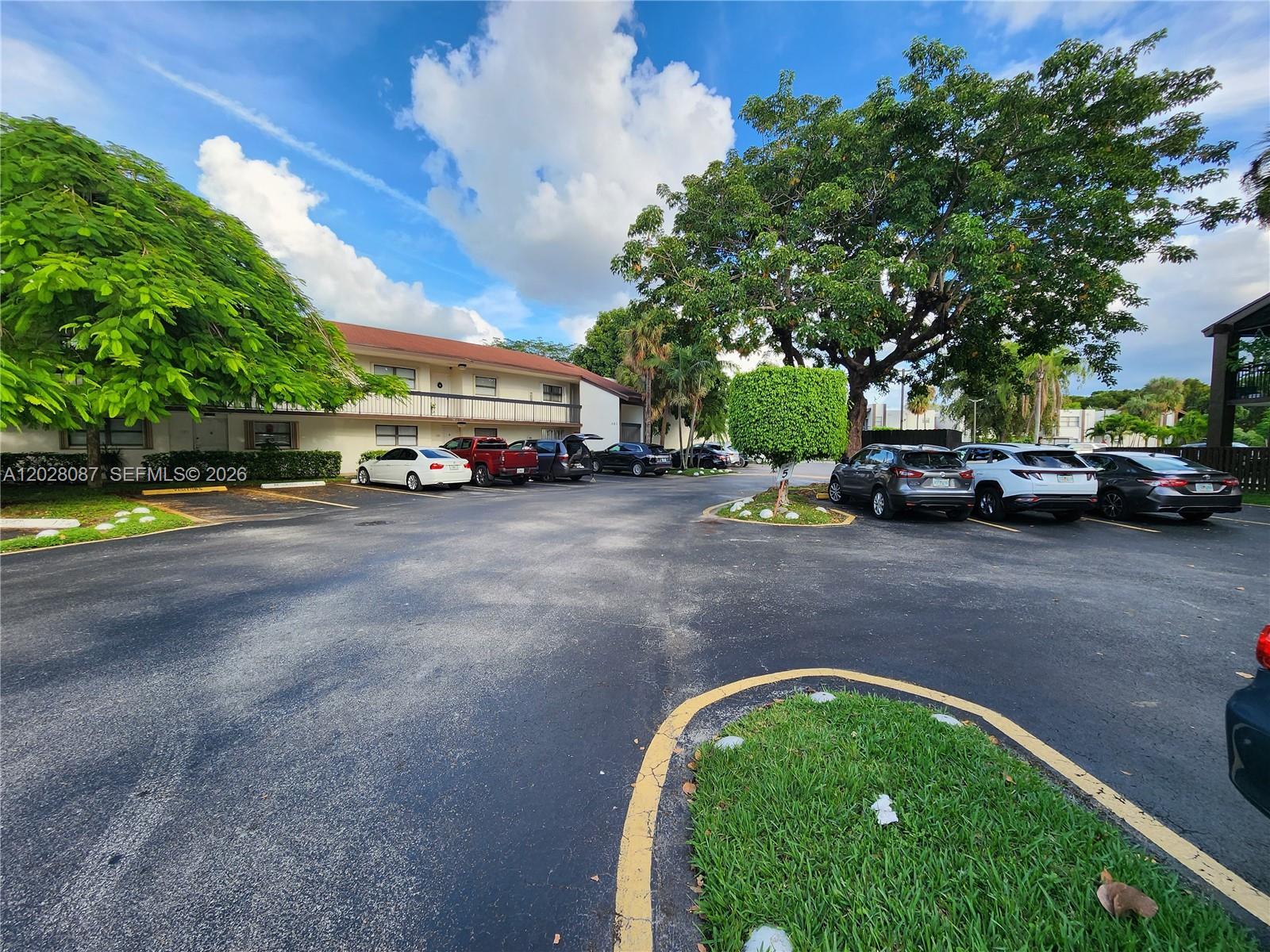 An exterior view shows a multi-story apartment building with a parking lot and trees — 461 NW 107 Ave # 102, Miami FL 33172, MIAMI, FL