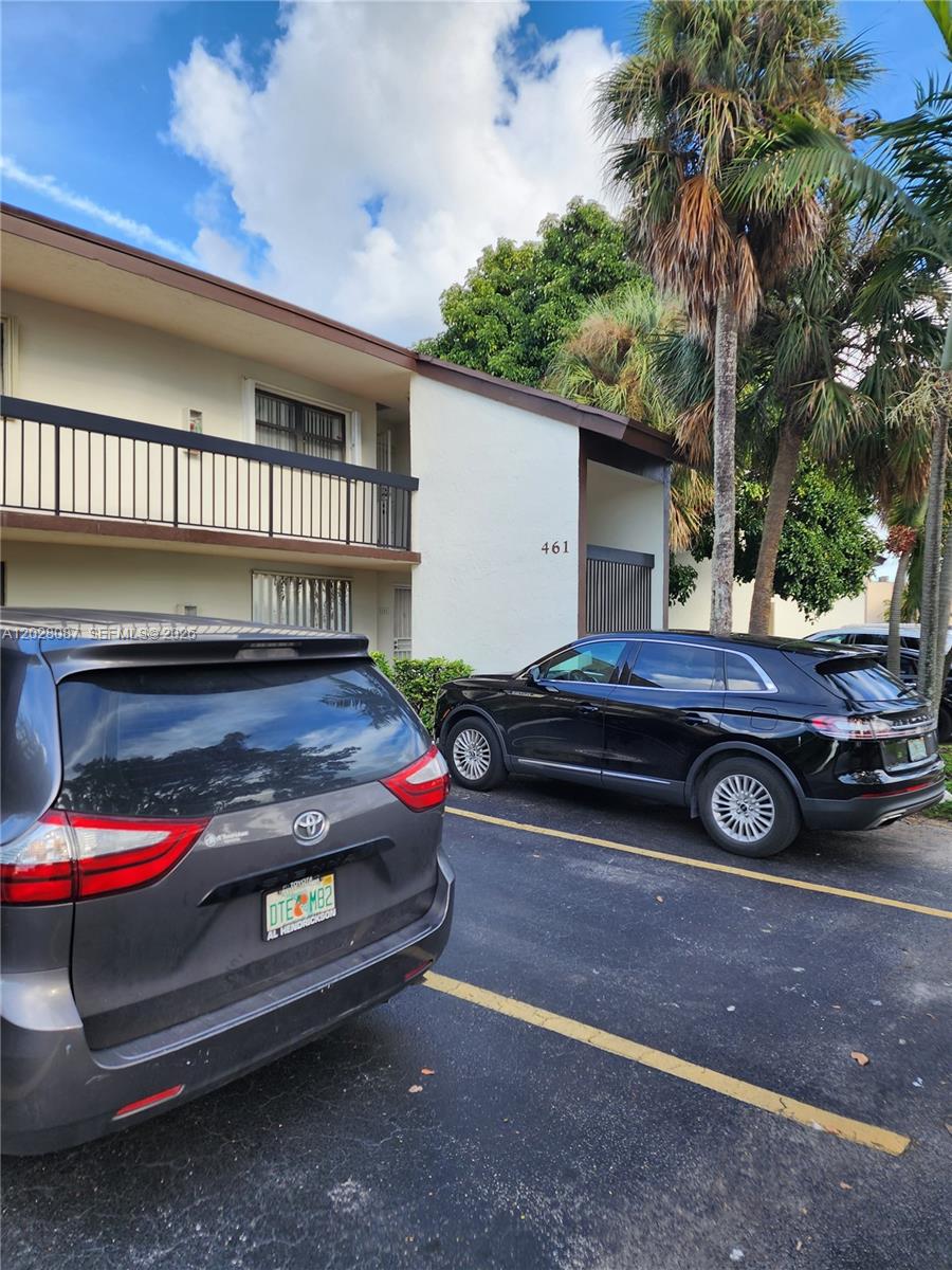 A two-story apartment building exterior with a parking lot and two parked cars — 461 NW 107 Ave # 102, Miami FL 33172, MIAMI, FL