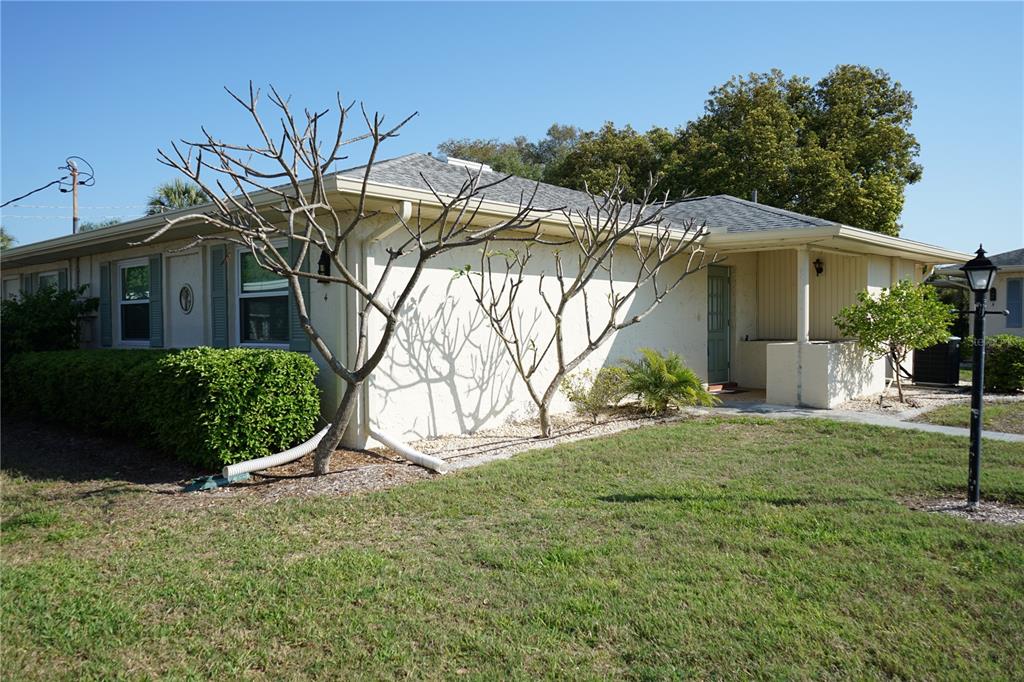 A single-story house with a light-colored exterior, a gray shingled roof, and bare trees — 1901 CANTERBURY LANE UNIT 4, SUN CITY CENTER, FL