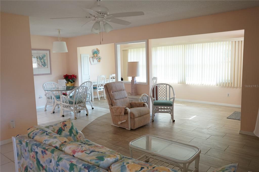 An open-concept living and dining area features light-colored tile flooring and a ceiling fan — 1901 CANTERBURY LANE UNIT 4, SUN CITY CENTER, FL