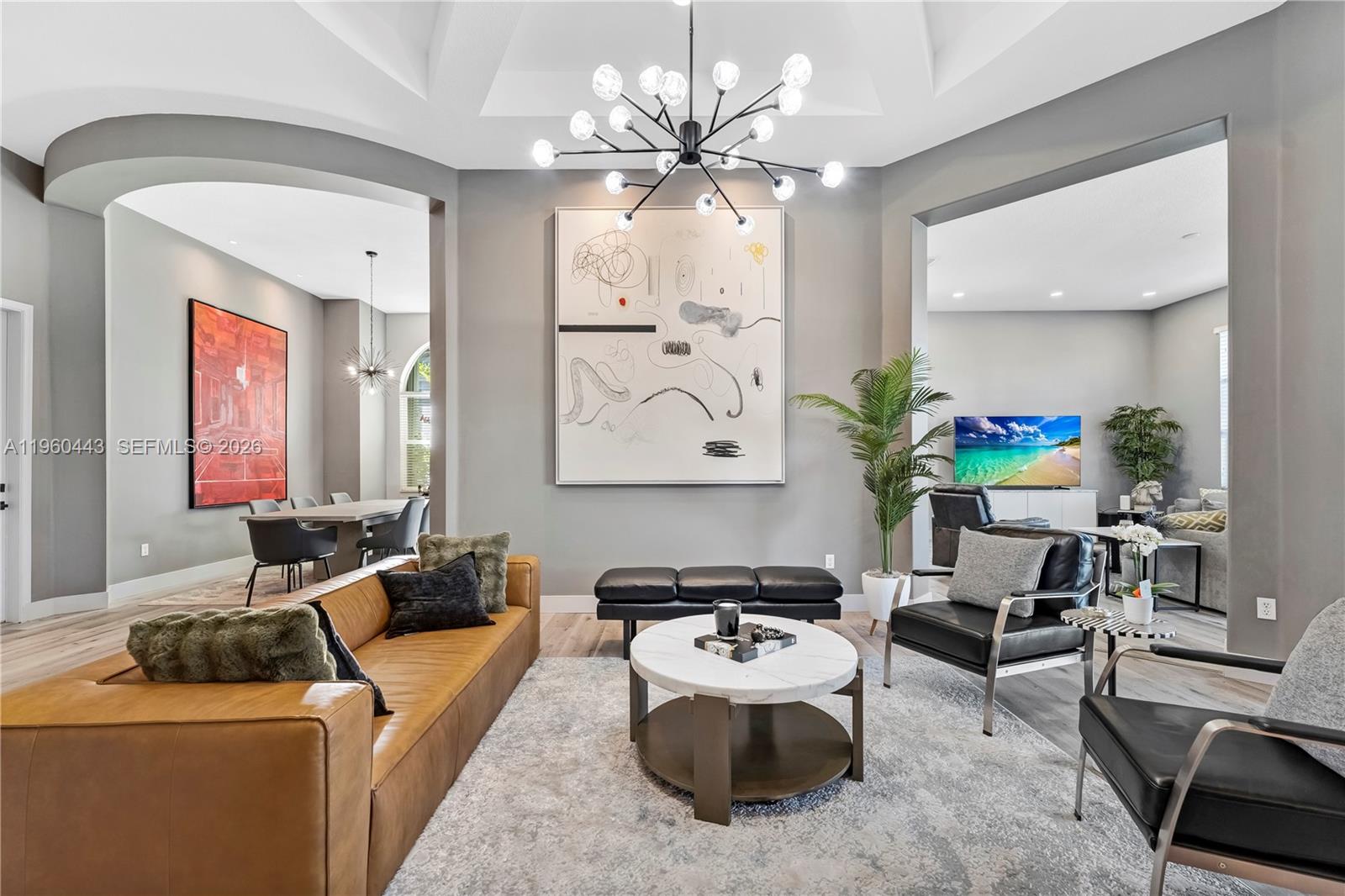 A modern living room features a tan leather sofa, black armchairs, and a large abstract painting — 5046 SW 162nd Ave, Miramar FL 33027, MIRAMAR, FL