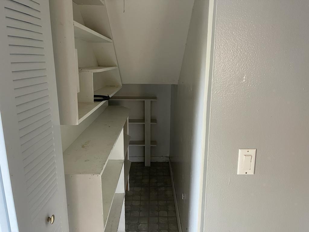 A small, narrow closet features white built-in shelving and gray vinyl flooring — 4664 Cherry Road, West Palm Beach FL 33417, WEST PALM BEACH, FL