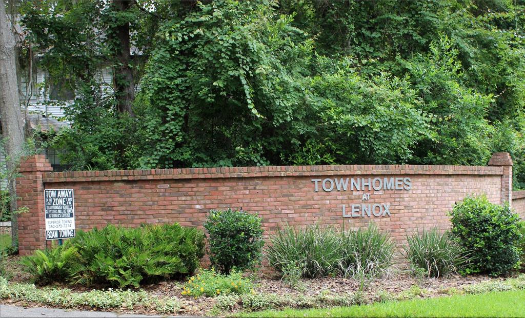 A brick wall with signage for Townhomes at Lenox stands in front of lush green trees — 831 NW 42ND TERRACE, GAINESVILLE, FL