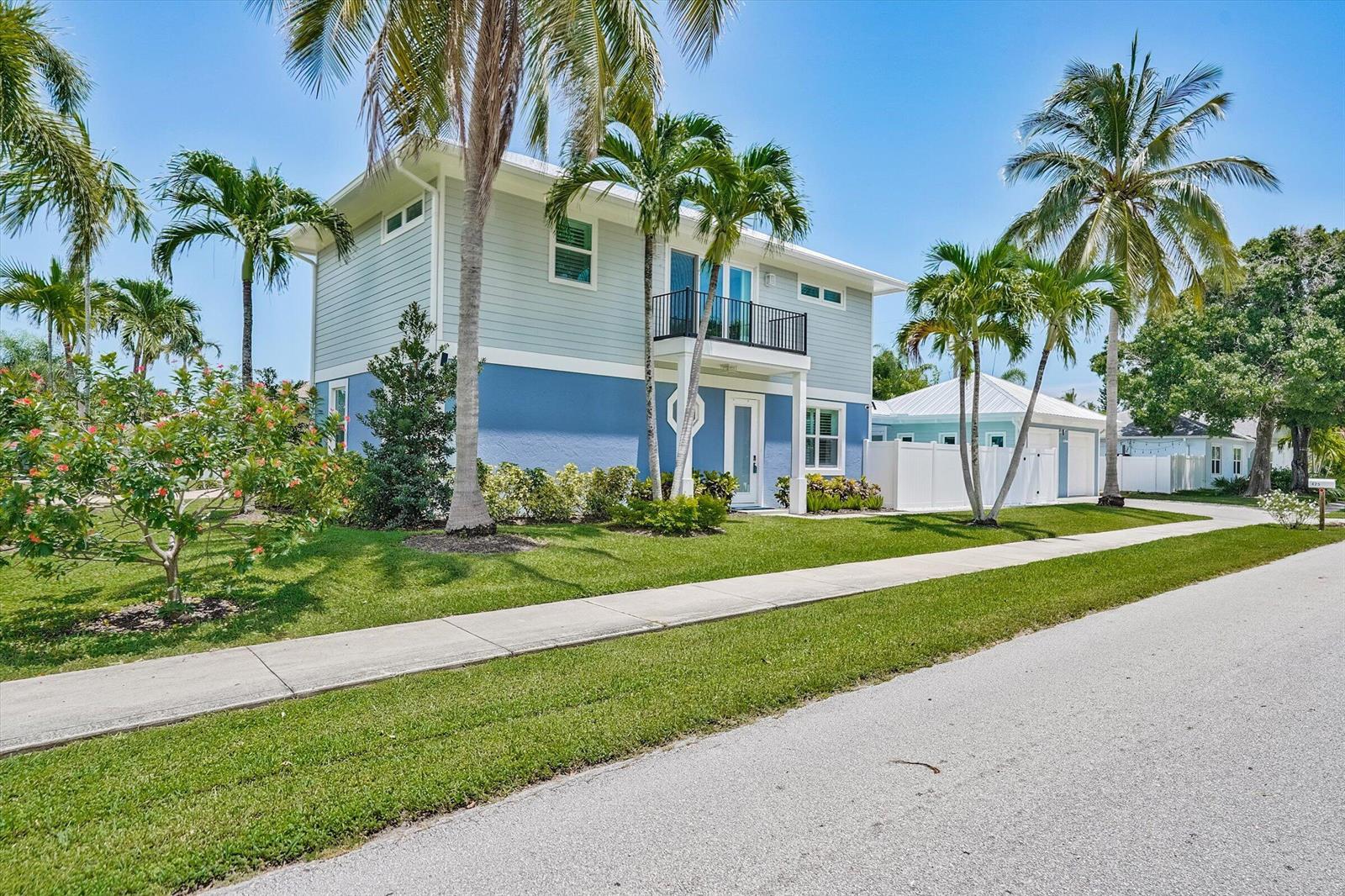 A two-story house with blue siding, a balcony, and palm trees in the front yard — 425 Hugh Street, Jupiter FL 33458, JUPITER, FL
