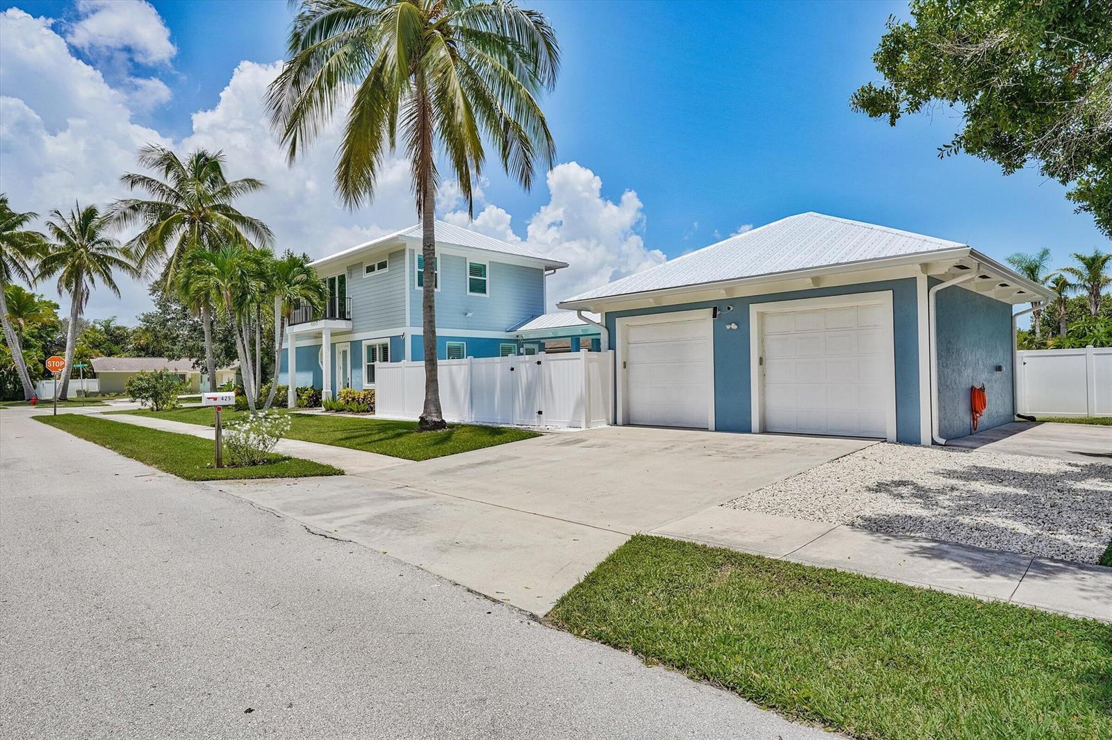 A two-story blue house with a detached two-car garage and palm trees in the yard — 425 Hugh Street, Jupiter FL 33458, JUPITER, FL