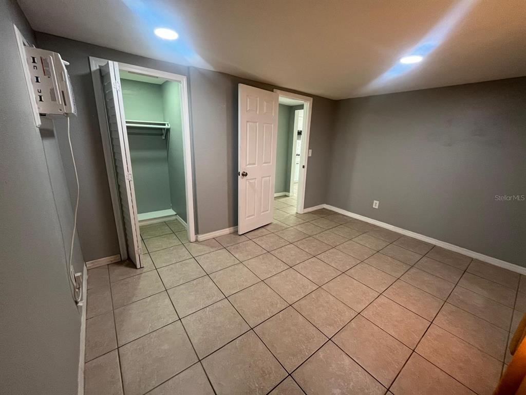 A room with gray walls, tiled flooring, a closet, and an open doorway — 1400 DAKOTA AVENUE, ST CLOUD, FL