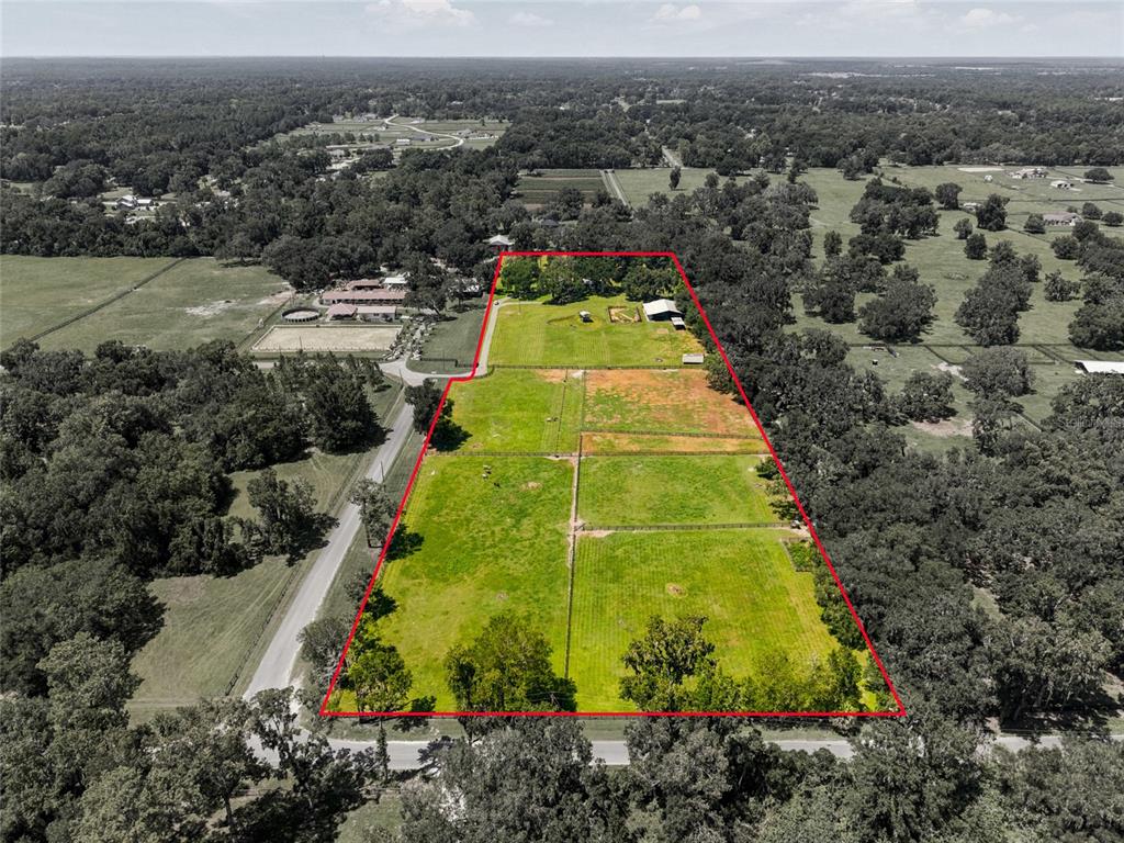 An aerial view shows a fenced rectangular property with pastures, trees, and outbuildings — 3875 SE 118TH LANE, BELLEVIEW, FL