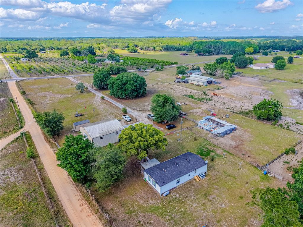 An aerial view shows a rural property with a house, a metal workshop, and outbuildings — 4536 EMPIRE CHURCH RD, GROVELAND, FL