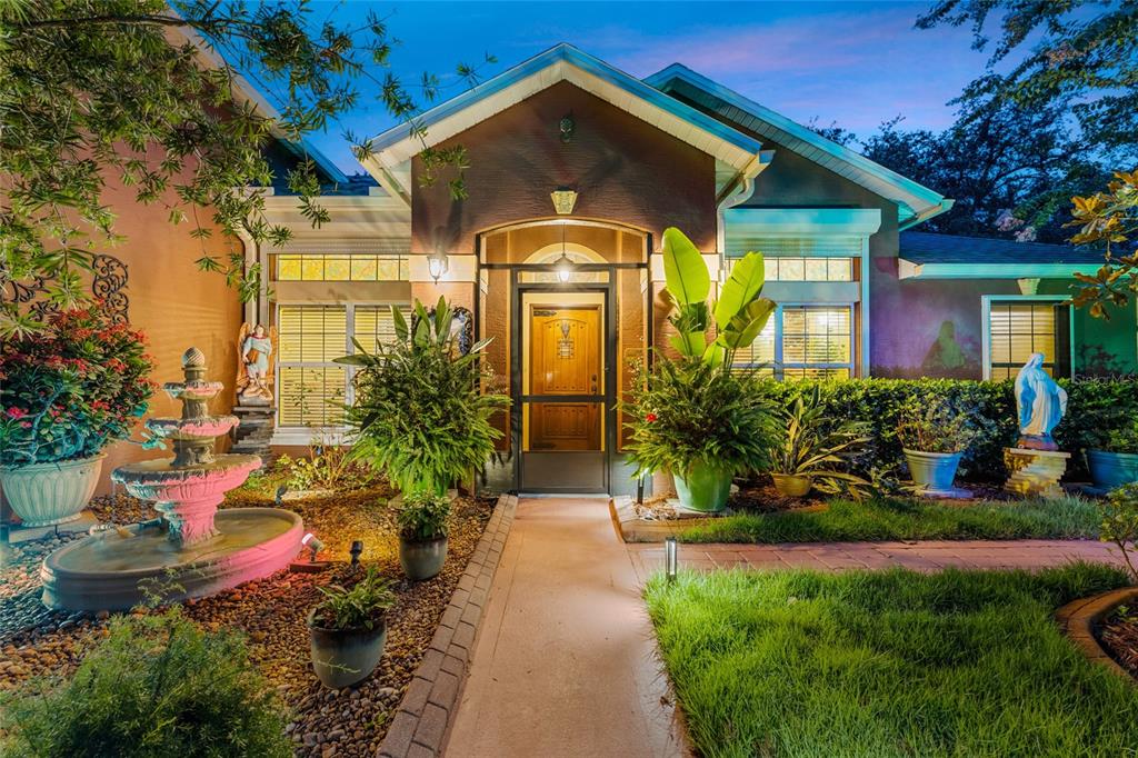 A front exterior view of a house with a fountain, walkway, and landscaping at dusk — 3 SEA BOARD COURT, PALM COAST, FL