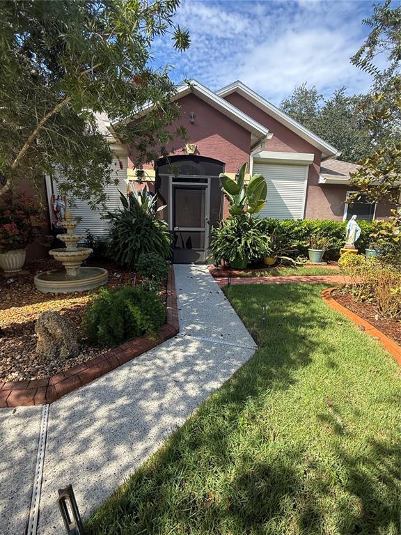 A front exterior view of a house with a fountain, landscaping, and a paved walkway — 3 SEA BOARD COURT, PALM COAST, FL