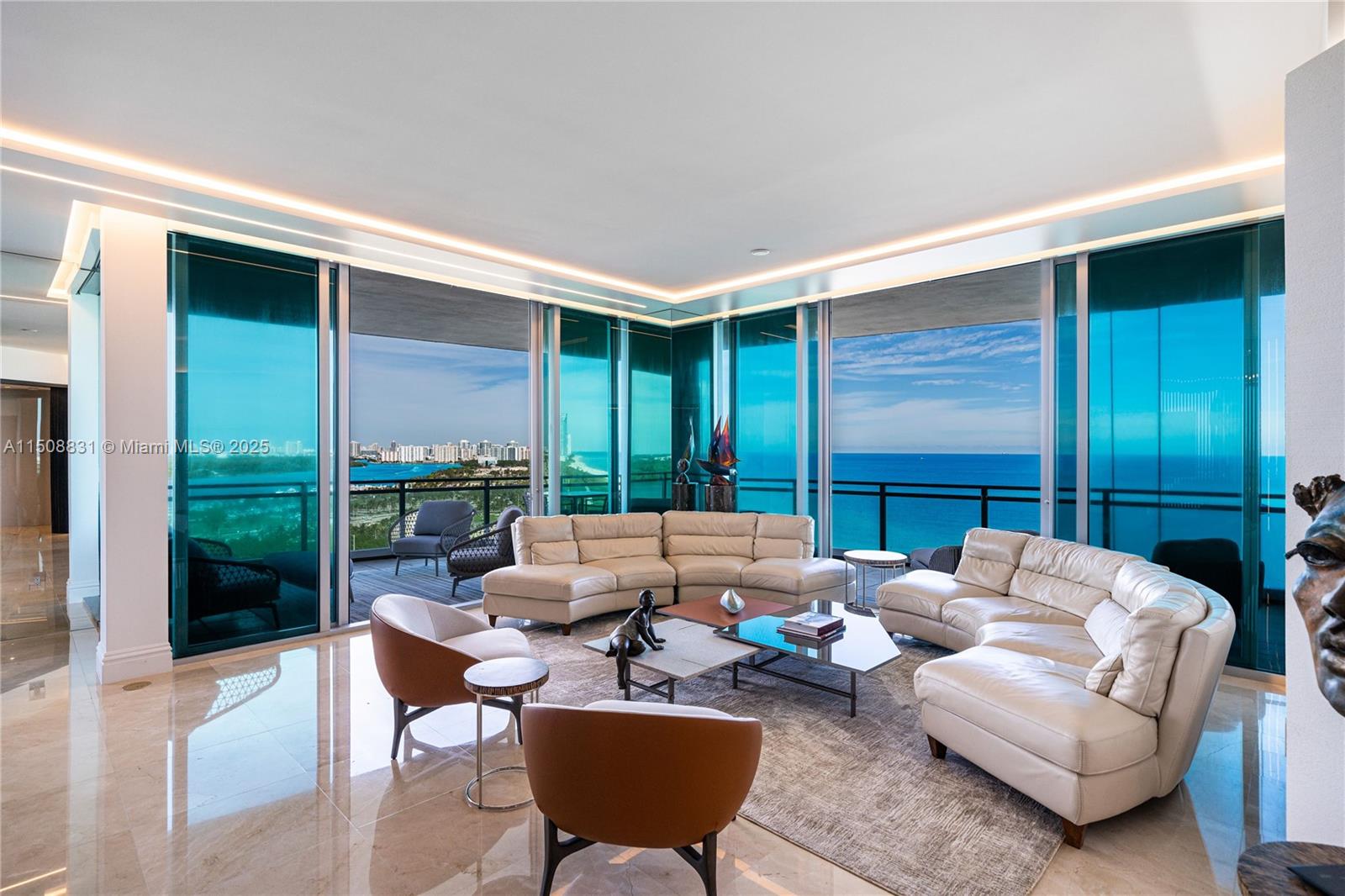 A living room with white leather sectionals, marble floors, and floor-to-ceiling windows overlooking the ocean — 10295 E Collins Ave # 1509, Bal Harbour FL 33154, BAL HARBOUR, FL