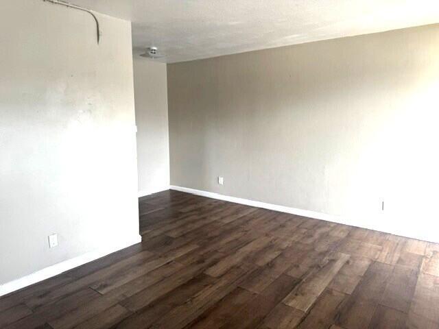 An empty room features light-colored walls, dark wood-look flooring, and a ceiling-mounted light fixture — 628 SW 4th Street, Belle Glade FL 33430, BELLE GLADE, FL