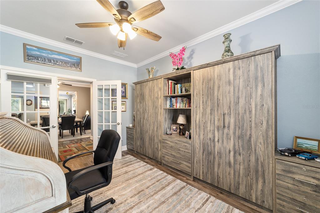 A home office features a roll-top desk, a large wood-grain wall unit, and French doors — 6612 SW 91ST CIRCLE, OCALA, FL