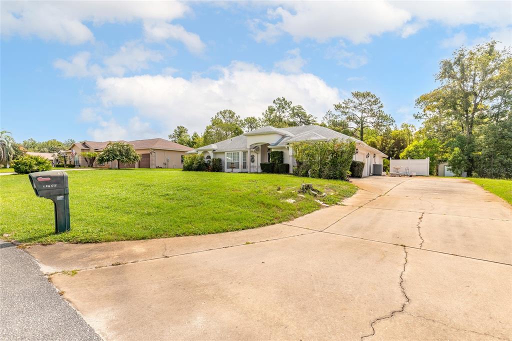 A single-story house with a large front lawn and a long concrete driveway — 10901 SW 55TH AVENUE, OCALA, FL